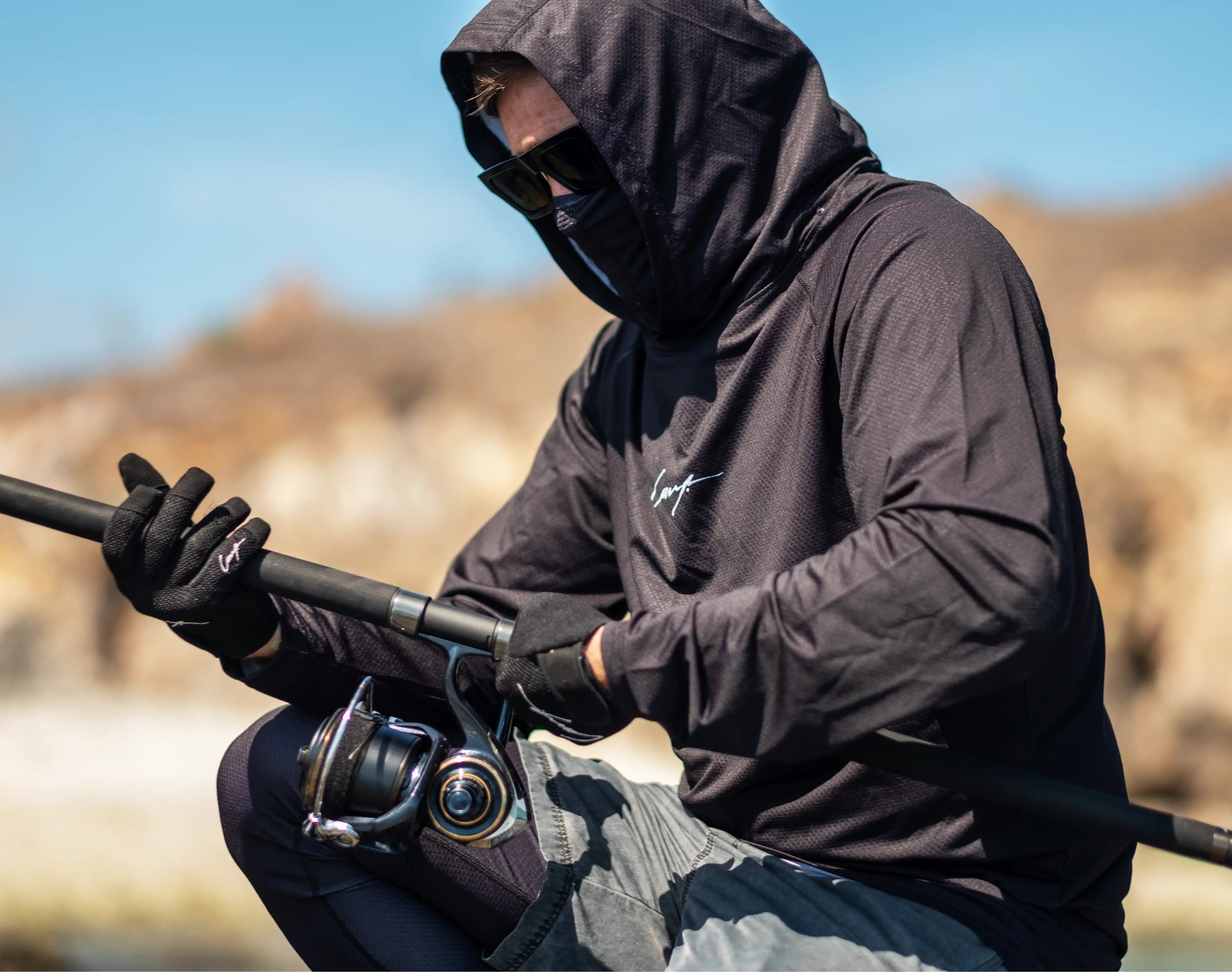 Angler wearing UV protection fishing shirt and gloves by Cavy Fishing while casting rod