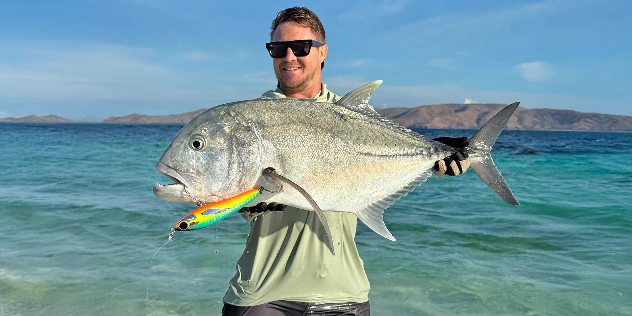 Close-up of handmade stickbait lure, painted and rigged for saltwater fishing.