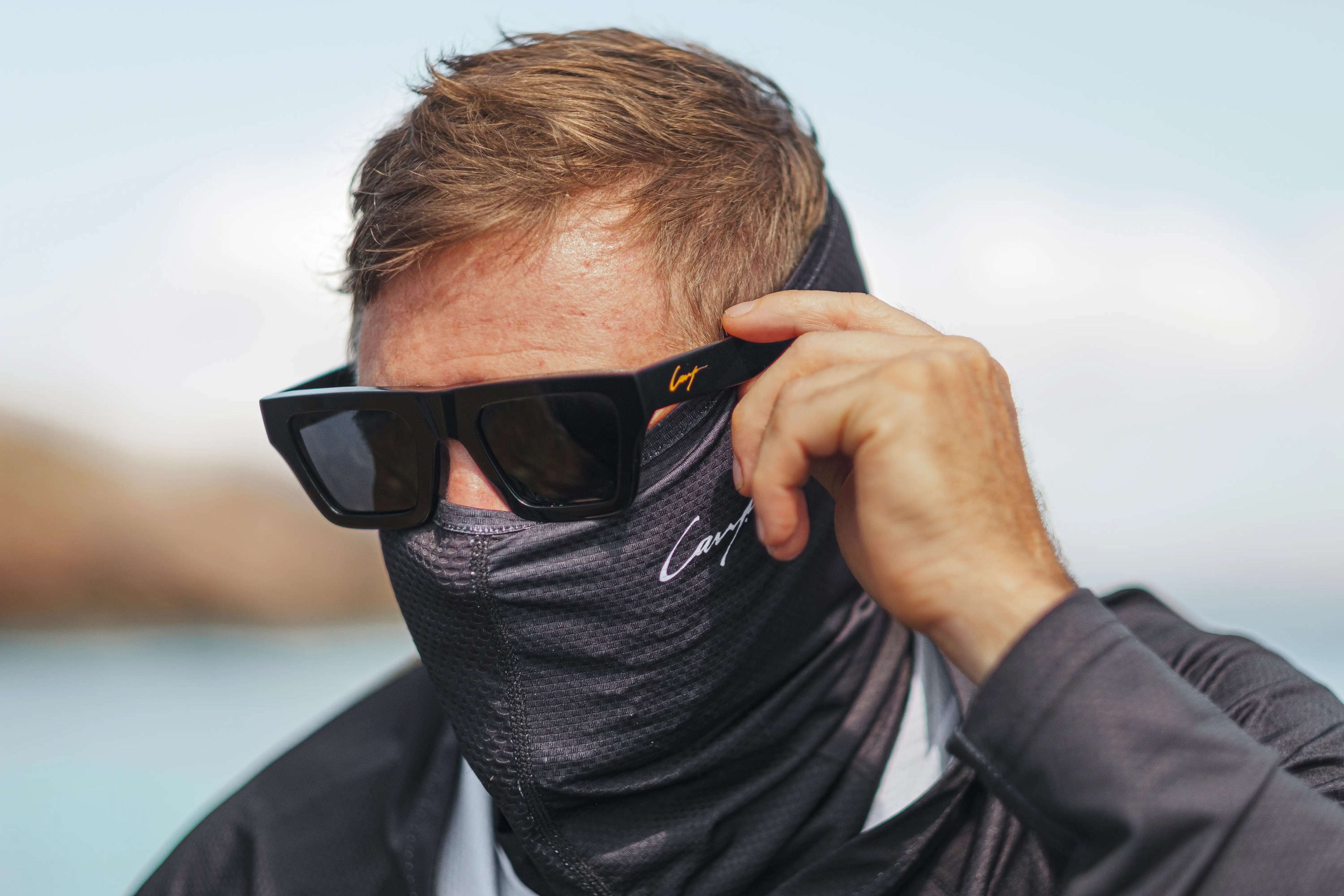 Angler wearing Cavy Fishing polarised sunglasses and UV shirt, reducing glare and protecting eyes while fishing in bright coastal conditions.
