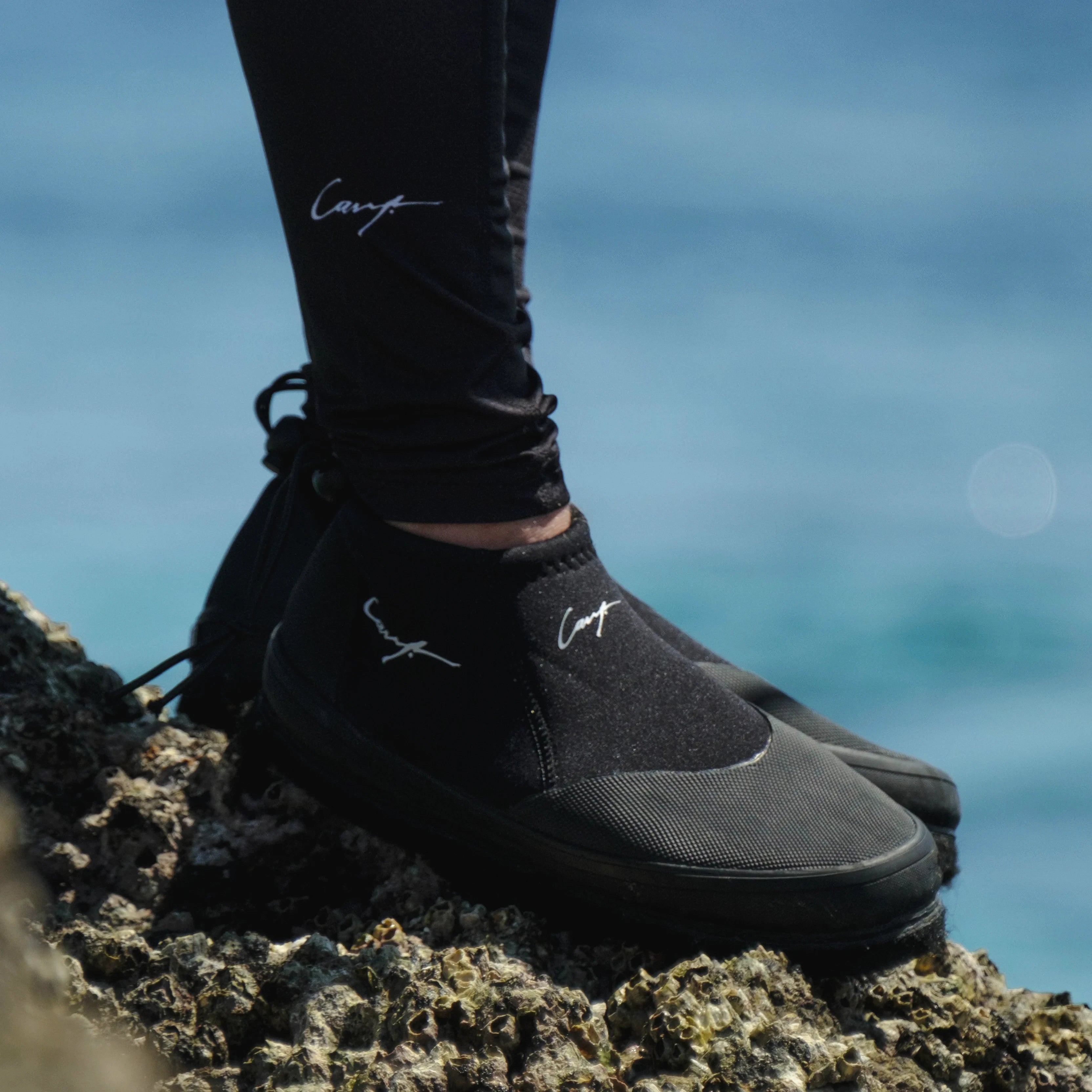 Close-up of Cavy Rock Hopper fishing shoes gripping reef rocks in shallow water