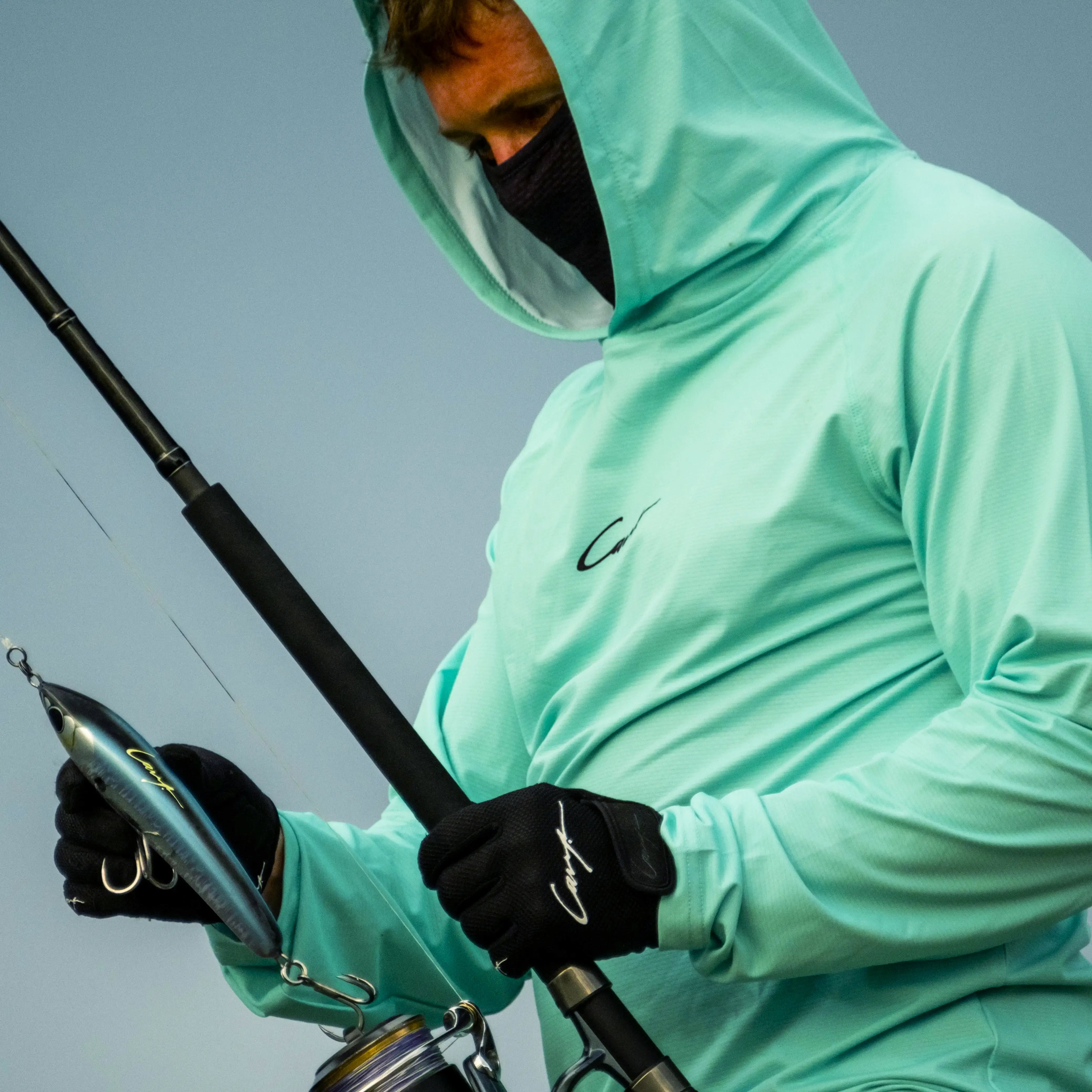 Angler wearing Cavy UV protection fishing shirt with hood and mask while casting offshore